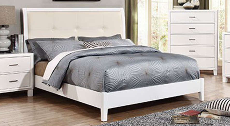 White bed frame with a grey mattress and accessories